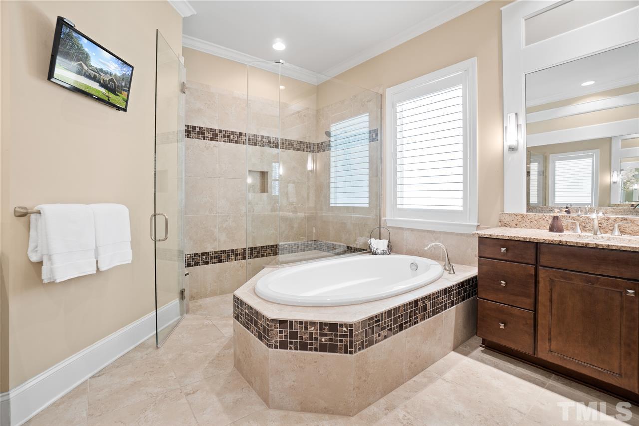 1504 Brassfield Road Raleigh, NC 27614 - Photo 16 of 30 a spacious bathroom with a tub sink shower and mirror