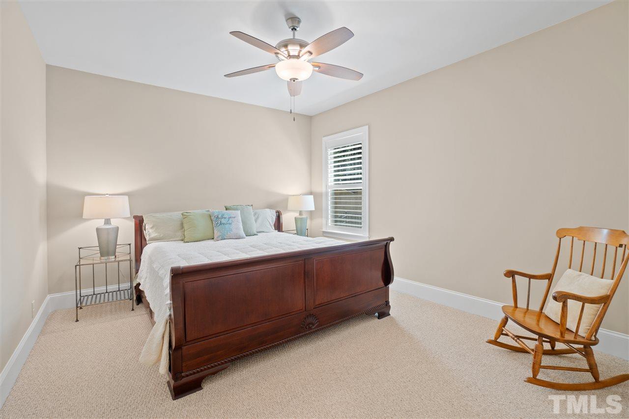 1504 Brassfield Road Raleigh, NC 27614 - Photo 20 of 30 a bedroom with a bed a chair and a chandelier