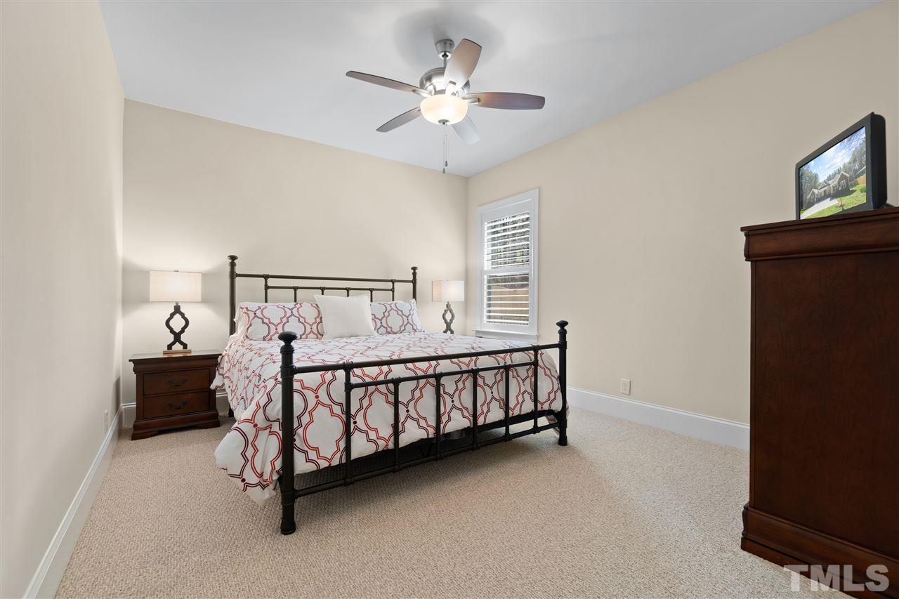 1504 Brassfield Road Raleigh, NC 27614 - Photo 22 of 30 a bedroom with a bed and a chandelier