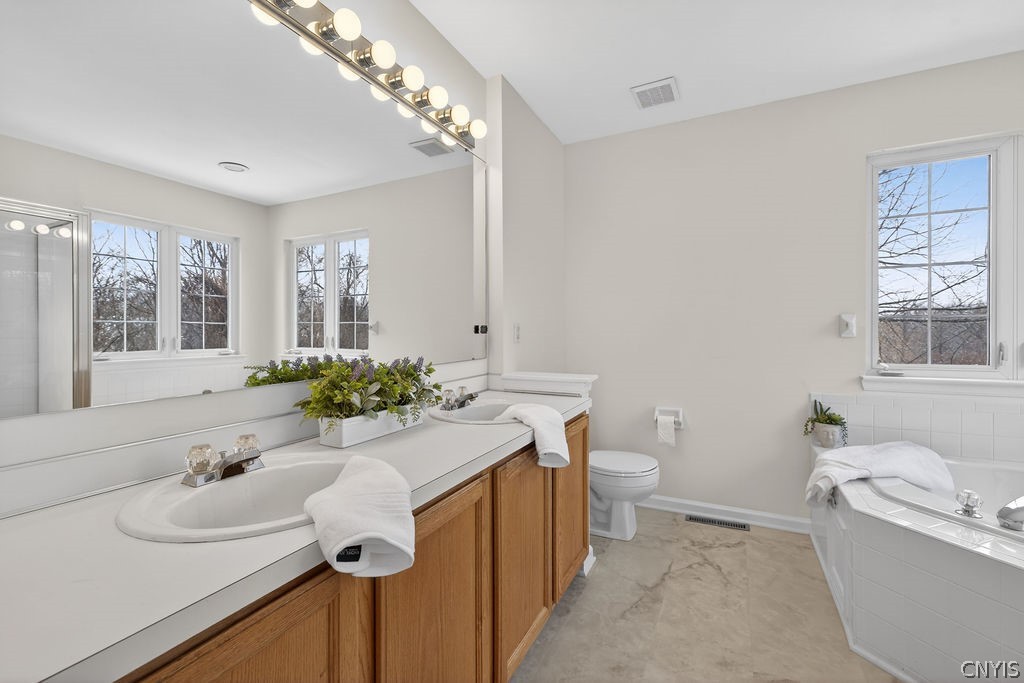 4848 Yenny Road Onondaga, NY 13215 - Photo 27 of 50 Primary bathroom with dual sinks, soaking tub, sta