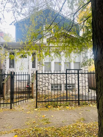 a view of a brick house with a large trees