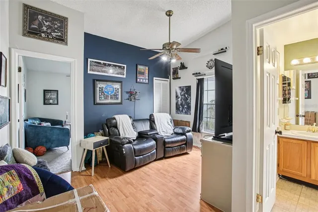 a living room with furniture kitchen view and a chandelier