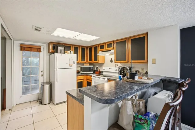 a kitchen with furniture a refrigerator and a view of living room