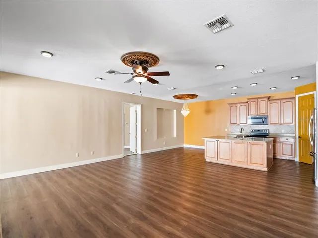 an empty room with windows and fan