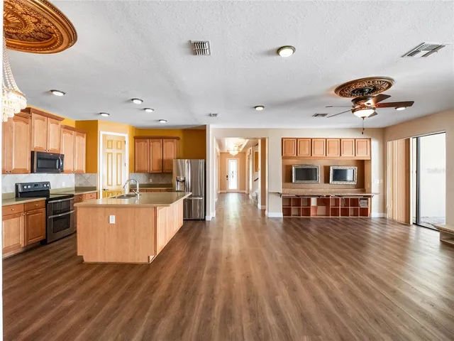 a view of a hallway with wooden floor and chandelier
