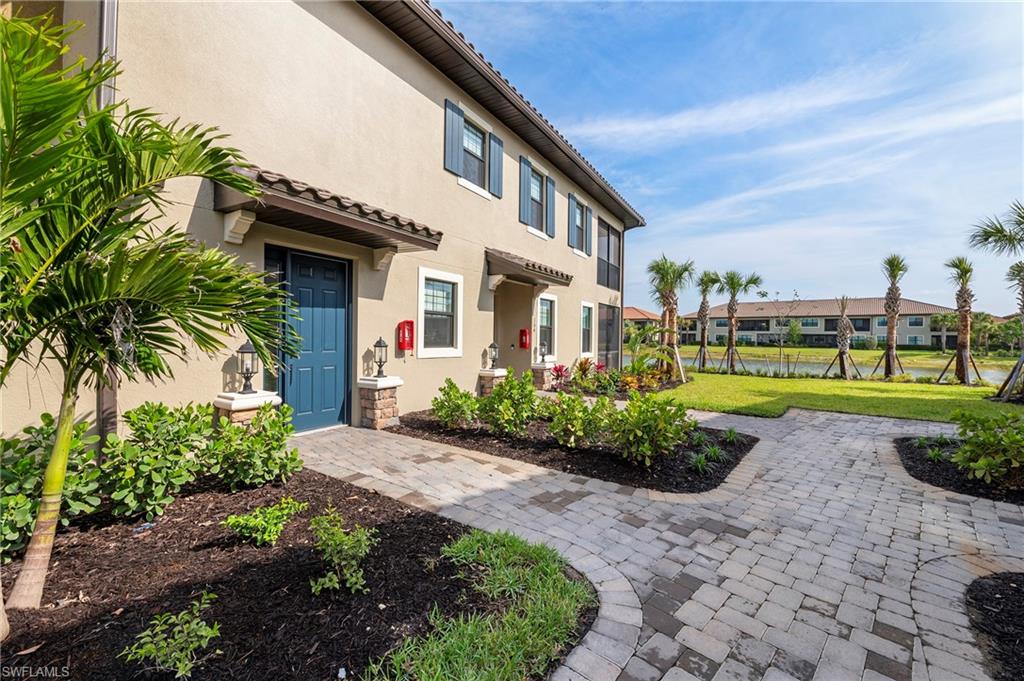 15327 Lucerna Street, Unit 204 Naples, FL 34114 - Photo 12 of 45 a front view of a house with a yard