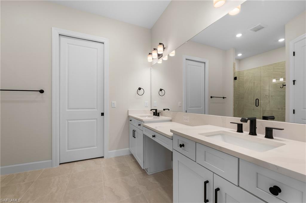 15327 Lucerna Street, Unit 204 Naples, FL 34114 - Photo 24 of 45 a spacious bathroom with a double vanity sink a mirror and a shower