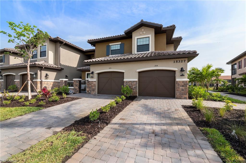 15327 Lucerna Street, Unit 204 Naples, FL 34114 - Photo 8 of 45 a front view of a house with a yard and garage