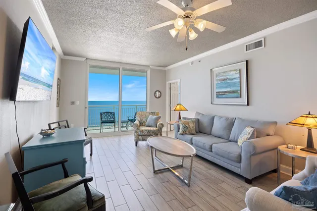 a living room with furniture a chandelier and a large window