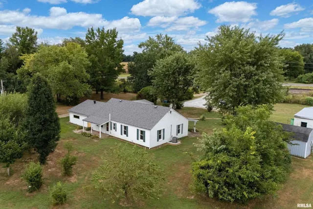 a aerial view of a house with a yard table and chairs