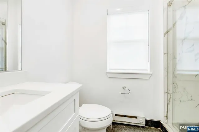 a bathroom with a sink toilet and a mirror