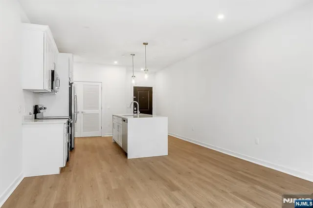 a view of kitchen with microwave and refrigerator