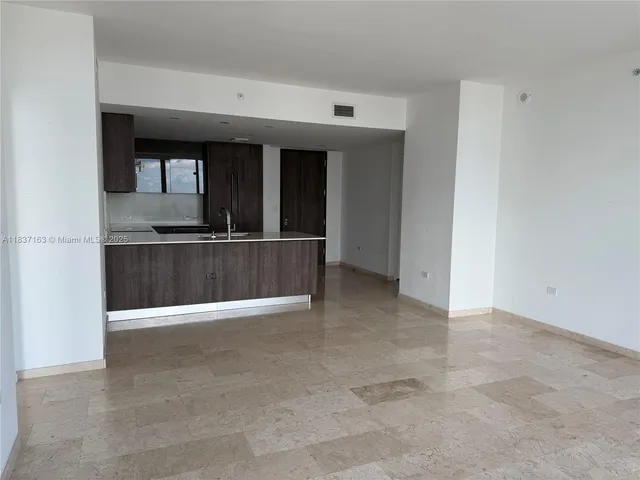 a kitchen with kitchen island a counter space and a refrigerator