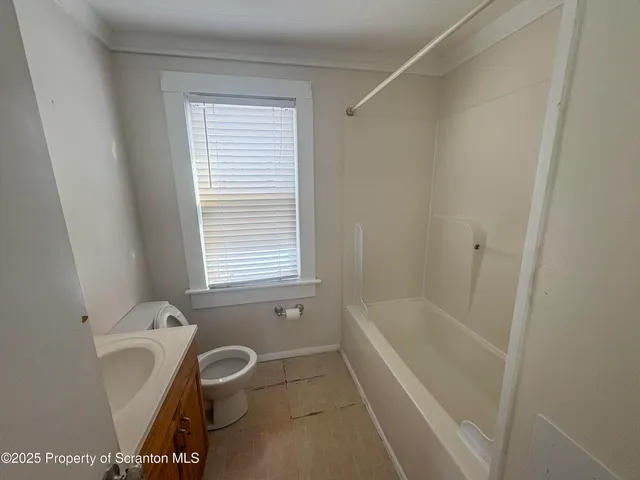 a bathroom with a bathtub a window and a shower