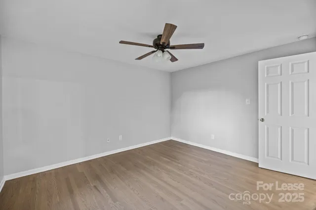 a view of a room with wooden floor and ceiling fan