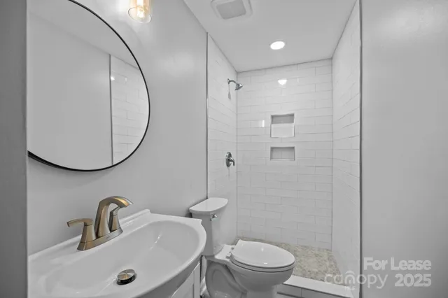 a bathroom with a sink a toilet and a mirror