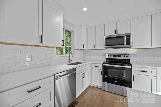 a kitchen with stainless steel appliances a stove sink microwave and cabinets