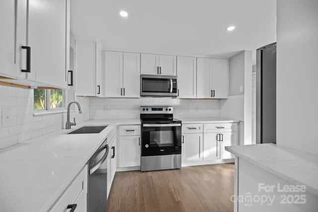 a kitchen with granite countertop a stove top oven a sink dishwasher and a refrigerator with wooden cabinets