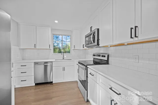 a kitchen with granite countertop white cabinets and white appliances