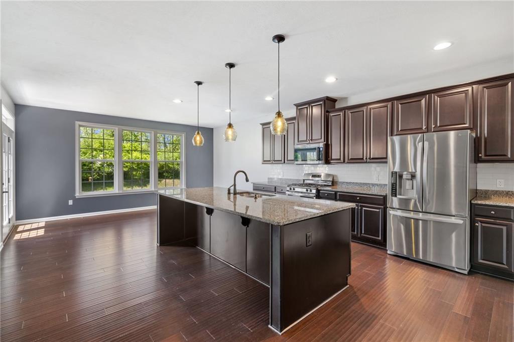 207 Gabriel Drive Mars, PA 16046 - Photo 12 of 47 a kitchen with stainless steel appliances granite countertop a refrigerator a sink dishwasher a stove and white cabinets with wooden floor
