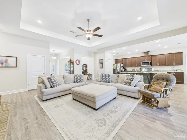 a living room with furniture and view of kitchen