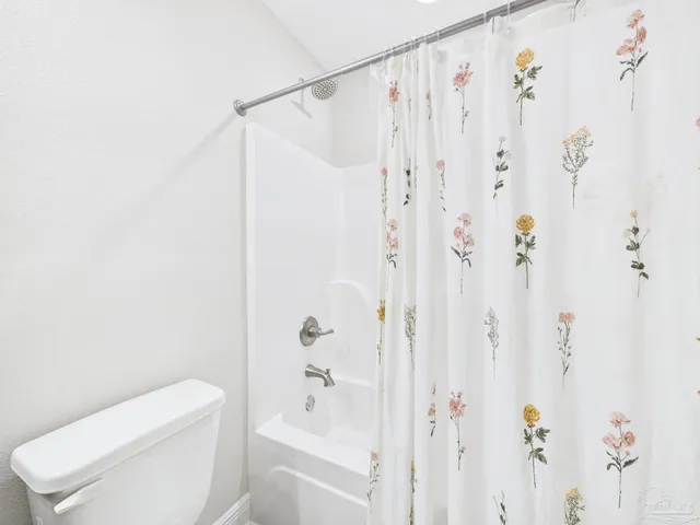 a bathroom with a shower curtain and a toilet