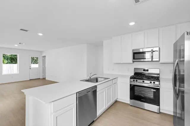 a kitchen with a sink and stainless steel appliances
