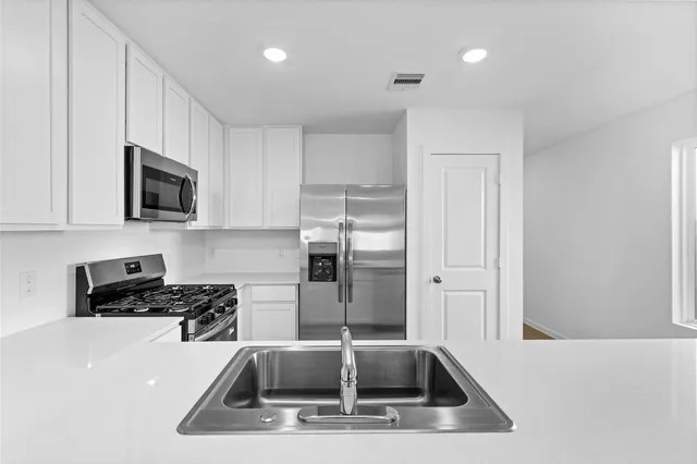 a view of a kitchen with kitchen island a window a counter top and a sink