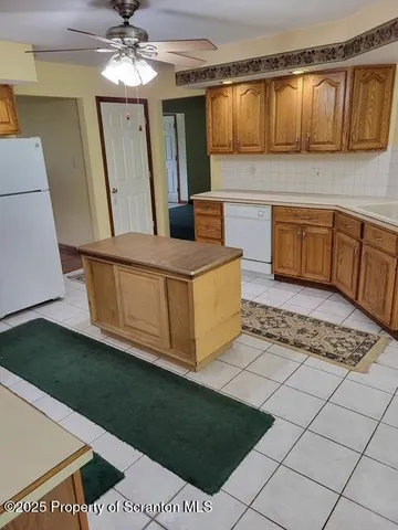 a living room with a couch and a dining table with wooden floor