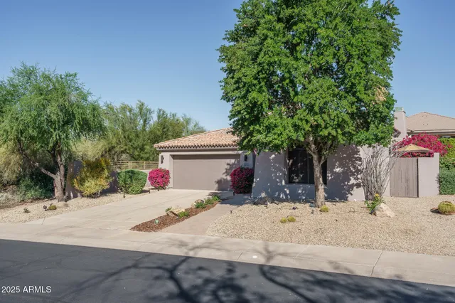 a view of a patio with table and chairs under an umbrella