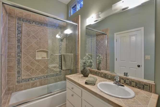 22154 Miller Ridge Road Los Gatos, CA 95033 - Photo 11 of 19 a bathroom with a shower sink vanity and mirror