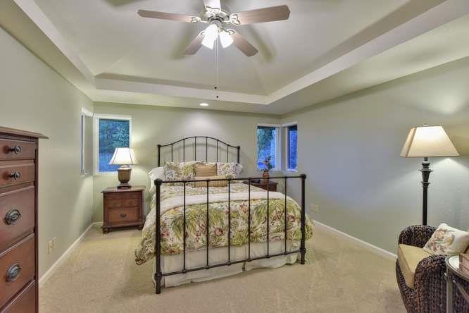22154 Miller Ridge Road Los Gatos, CA 95033 - Photo 10 of 19 a bedroom with a bed and a chandelier