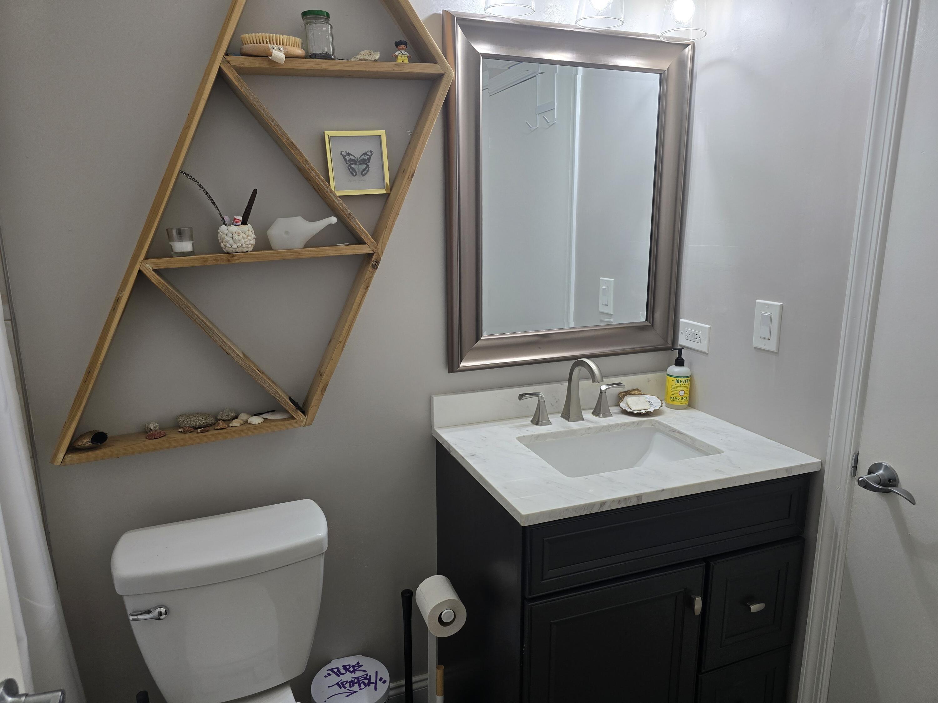 1215 Crystal Way, Unit O Delray Beach, FL 33444 - Photo 12 of 14 a bathroom with a toilet sink and mirror