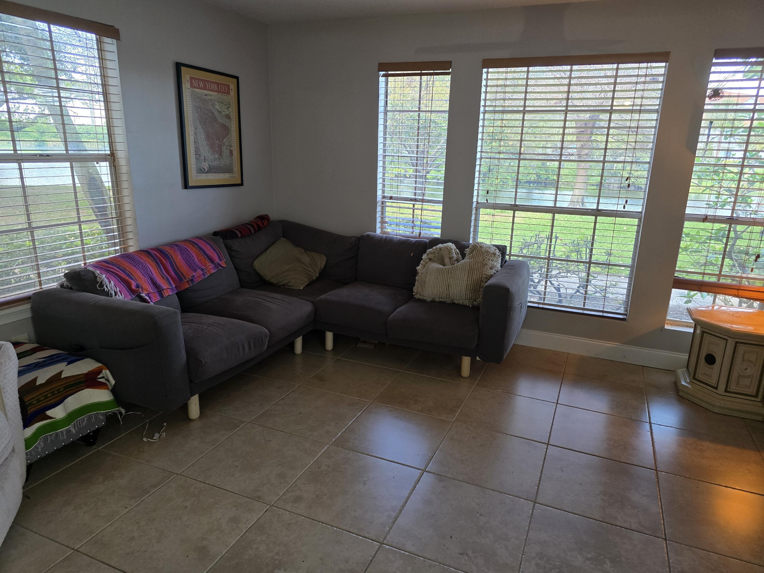 1215 Crystal Way, Unit O Delray Beach, FL 33444 - Photo 5 of 14 a living room with furniture and a floor to ceiling window
