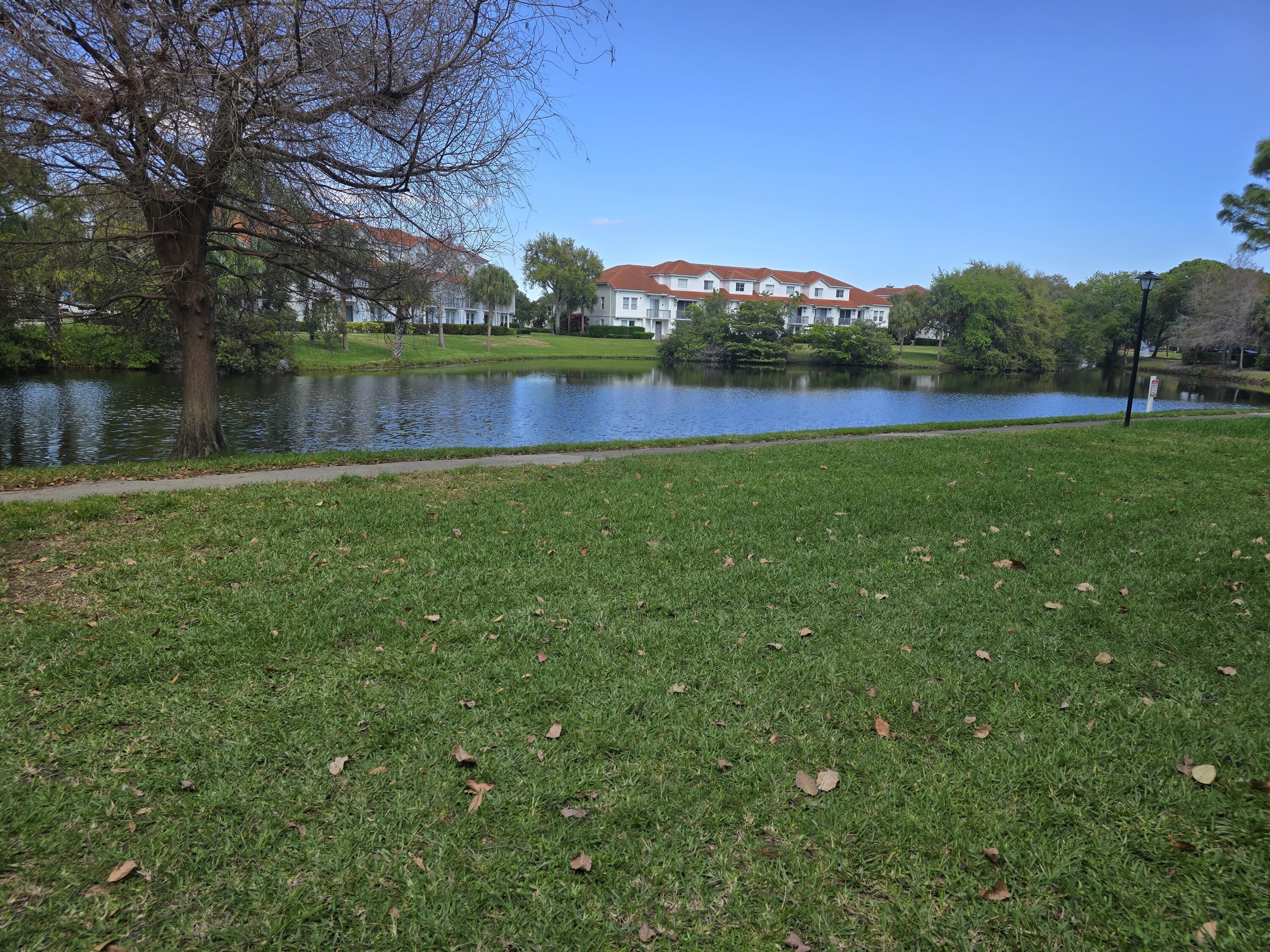 1215 Crystal Way, Unit O Delray Beach, FL 33444 - Photo 8 of 14 a view of a green field with wooden fence