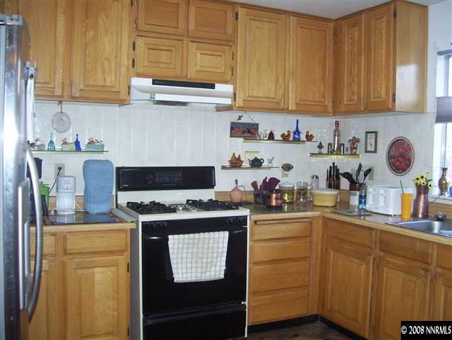 11590 Osage Road Reno, NV 89508 - Photo 2 of 9 a kitchen with stainless steel appliances granite countertop a stove a sink dishwasher and cabinets with wooden floor