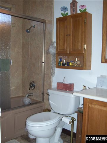 11590 Osage Road Reno, NV 89508 - Photo 4 of 9 a bathroom with a sink toilet a mirror and shower