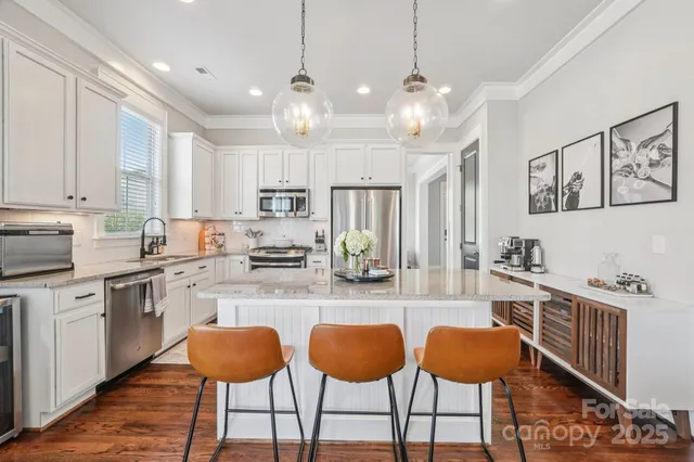a kitchen with stainless steel appliances granite countertop a stove refrigerator and cabinets
