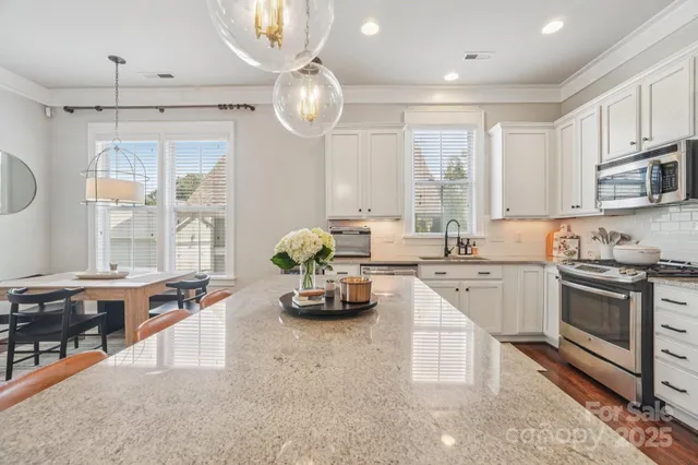 a kitchen with stainless steel appliances granite countertop a stove a sink and a refrigerator