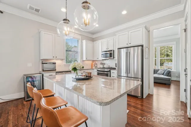 a living room with furniture kitchen view and a large window