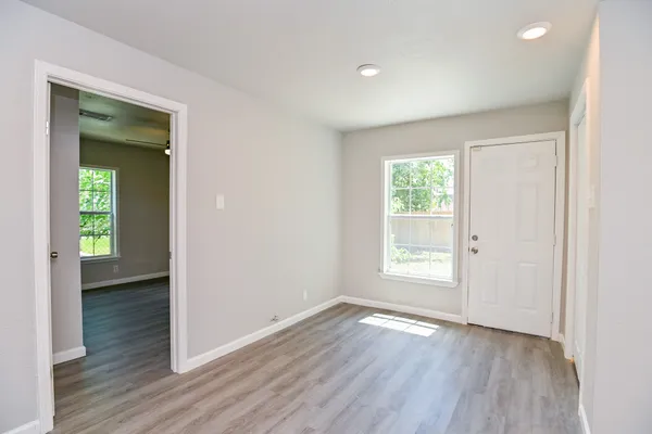 an empty room with wooden floor and a window