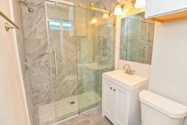a bathroom with a shower a sink and a toilet