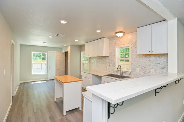 a kitchen with a sink cabinets and wooden floor