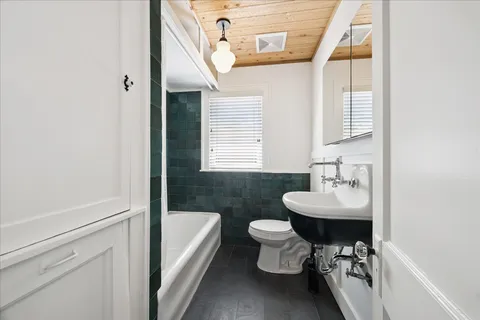 a bathroom with a sink toilet a mirror and bathtub