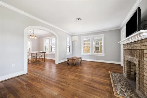 an empty room with wooden floor and a fireplace