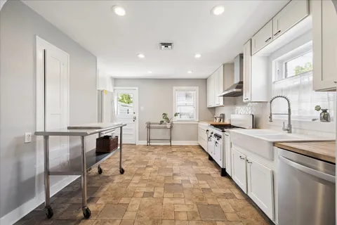 a large white kitchen with cabinets