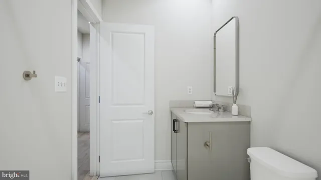 a bathroom with a granite countertop sink and a toilet