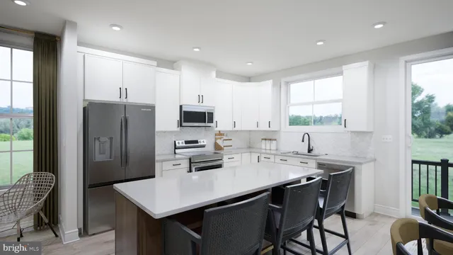 a kitchen with stainless steel appliances a sink a stove a refrigerator cabinets and a dining table with wooden floor