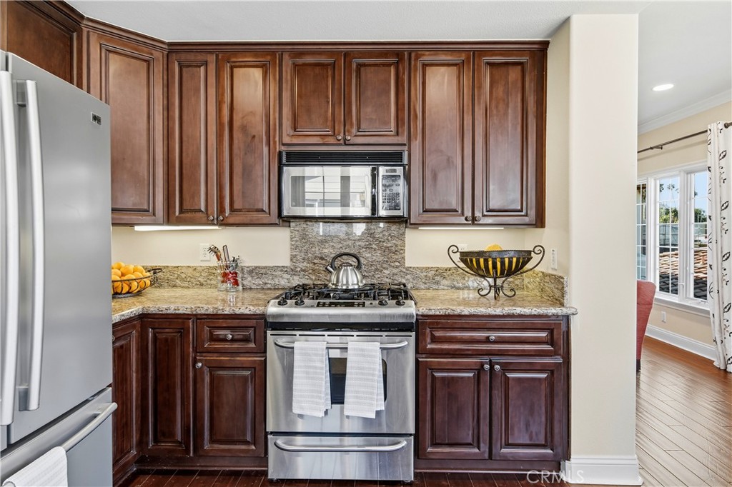2454 Oswego Street, Unit 301 Pasadena, CA 91107 - Photo 19 of 59 a kitchen with stainless steel appliances granite countertop wooden cabinets a stove a sink and a refrigerator