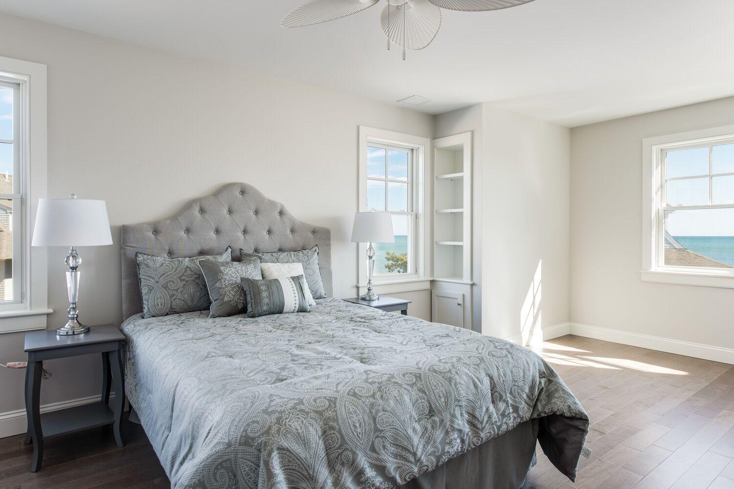 6 Beach Road Mashpee, MA 02649 - Photo 13 of 25 a large bed sitting in a bedroom next to a window and a chandelier